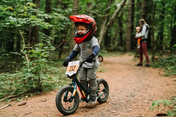 Small child on small mountain bike with full face red helmet