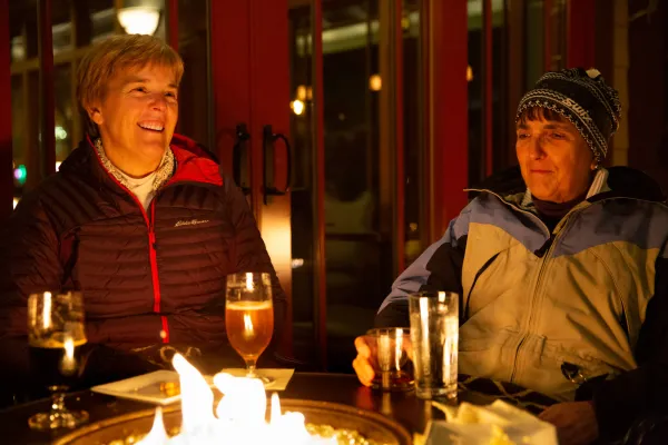 People enjoying cocktails by a fire for the Lake Placid Film Festival.