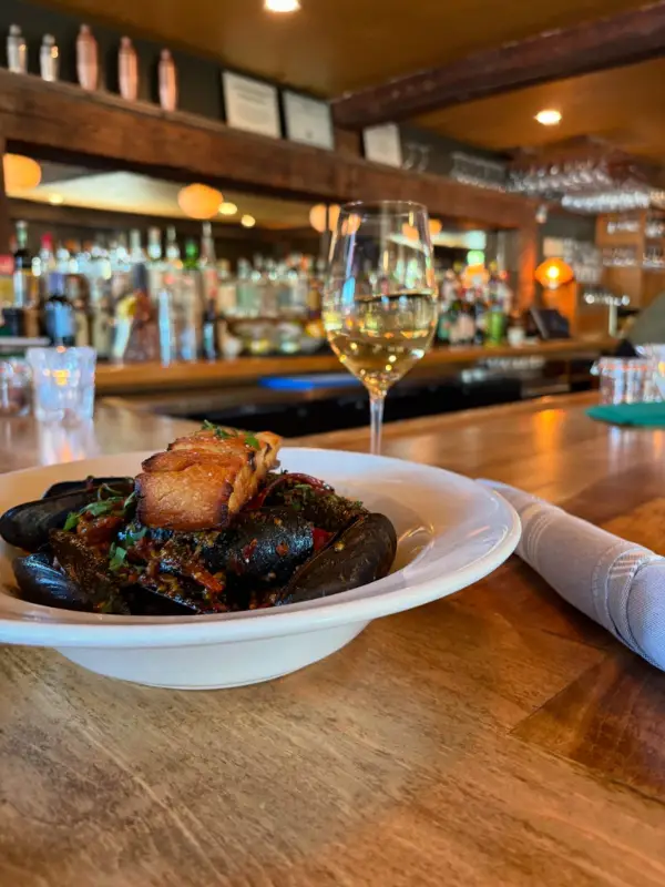 A delicious meal with a glass of wine at the bar