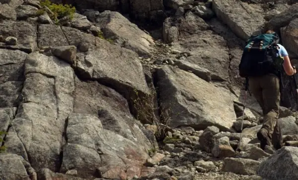 A hiker ascending a steep rocky trail