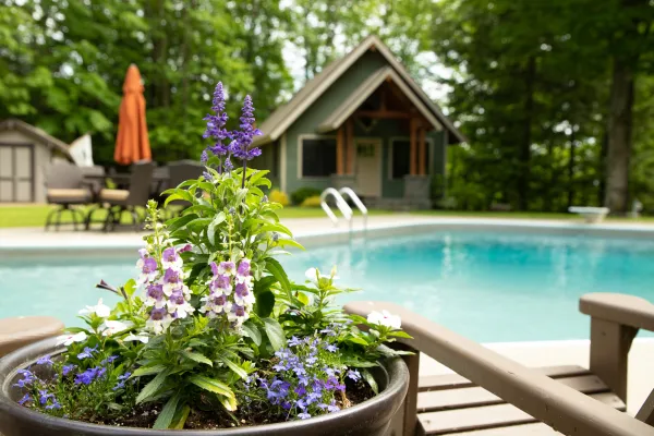 A pool with a cabin in the background.