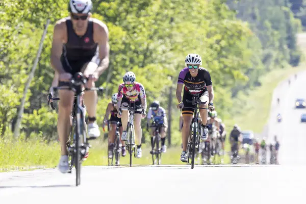 A large group of cyclists going up a road