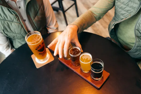 A man and woman share a flight of beers. 