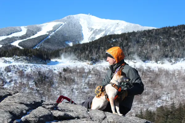 A man poses with a dog on Bear Den Mountain