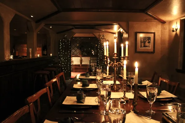 A long dark table lit with candle light.