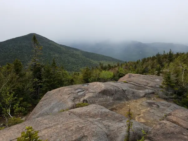 The view of a pointed mountain from a bare rock summit