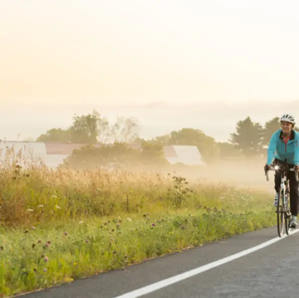 A biker rides down a secluded misty field