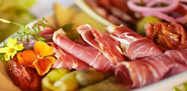 Delectable meats and cheeses on a plate.