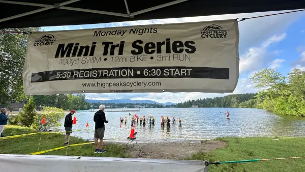 View of mini tri swim start from under pop-up tent with back of banner along top of frame