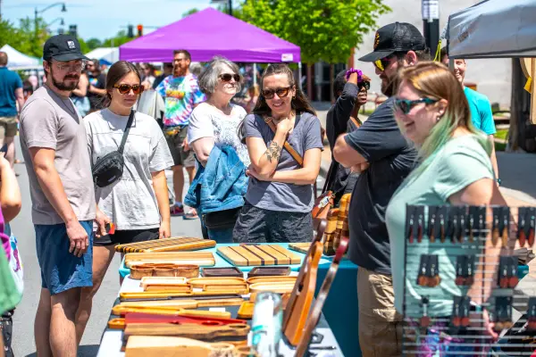A crowd of people enjoying an event during a sunny day.