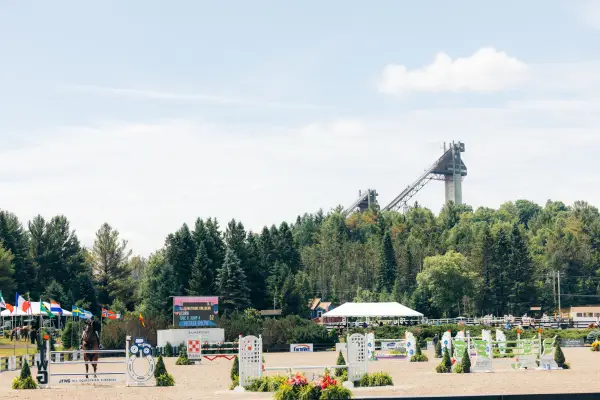 View of Lake Placid Horse Show Grounds during annual horse show with courses set up and ski jumps in the background