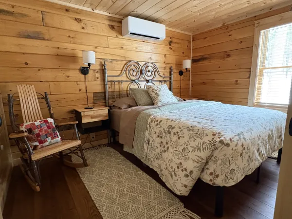 A second black framed bed in a wood paneled room