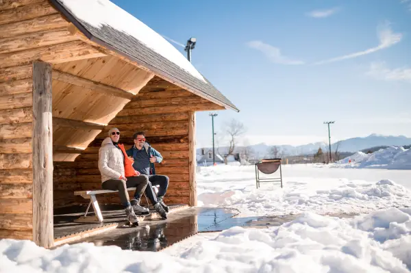 A couple laces up their skates in a lean-to at the Oval