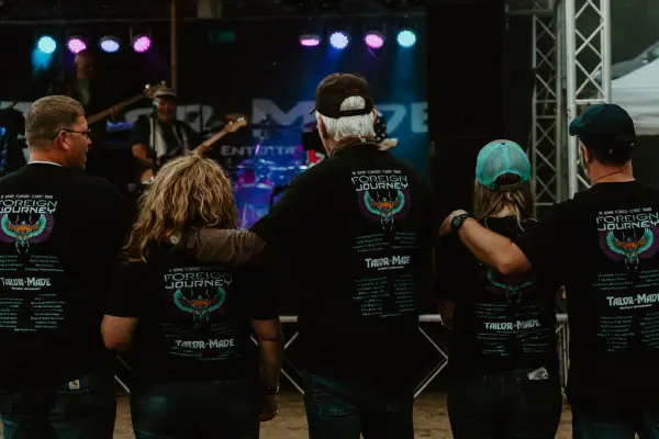 Concert-goers in band t-shirts watch show