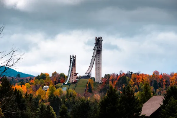 Ski jumps over fall foliage. 