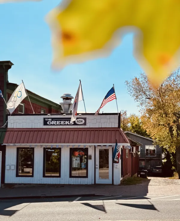 The exterior of The Greeks ADK surrounded by fall color