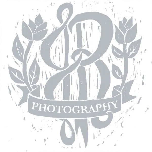 Logo with intertwined J & R, a banner reading Photography & two illustrated flower vines on either side.