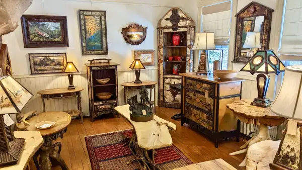 Red ceramics stand out boldly against the white bark of the corner hutch, off set by end tables with live edge tops and root ball bases.