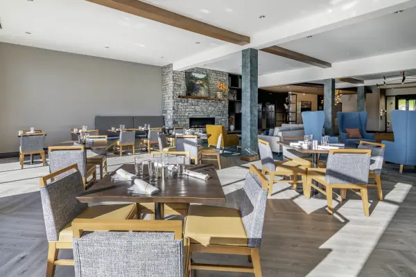 Dining in comfortable chairs with ample space and fireplace while enjoying the view of the mountains and Lake Placid from Haystack!
