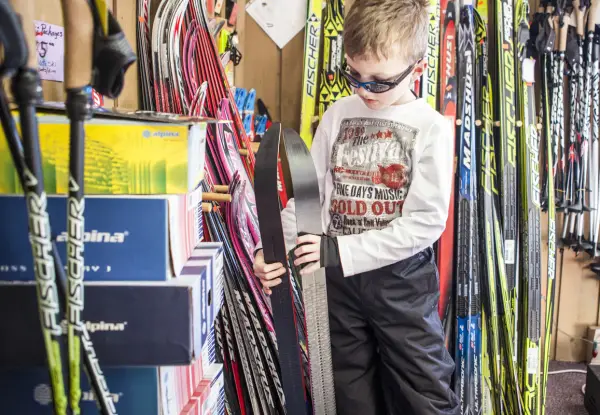 A young kid looks at skis