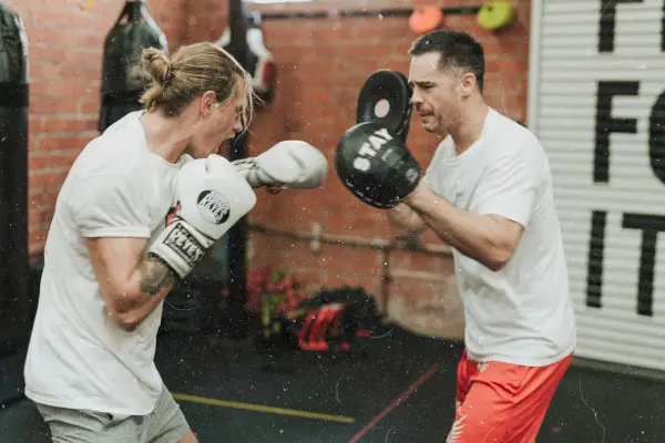 Two people sparring in a boxing ring.