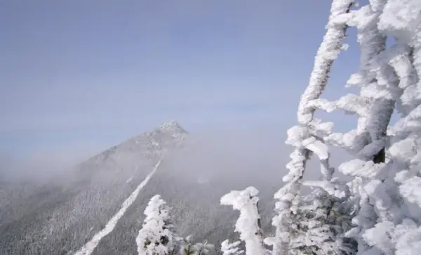 A winter view of a high mountain with a rock slide on it