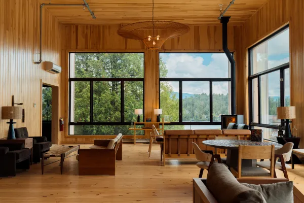 The fully wooden double height lobby with grand windows overlooking Mirror Lake with ample warm leather seating and fireplace