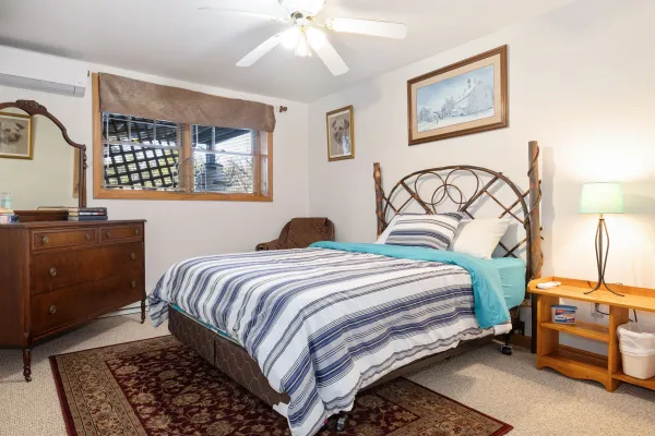 A lower level bedroom with blue striped sheets at the crib at Lake Placid Pinehill Townhouse.