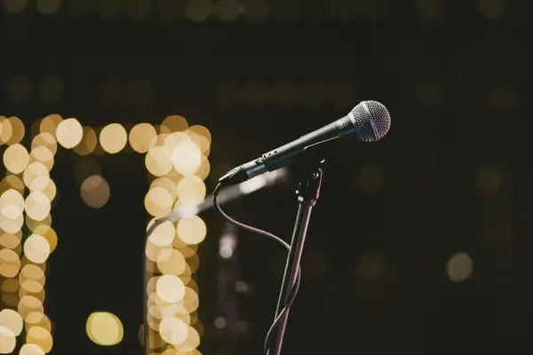 Stock image of microphone on stand with glowing lights in background