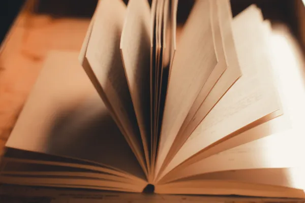 Stock image of open book on table with pages turning