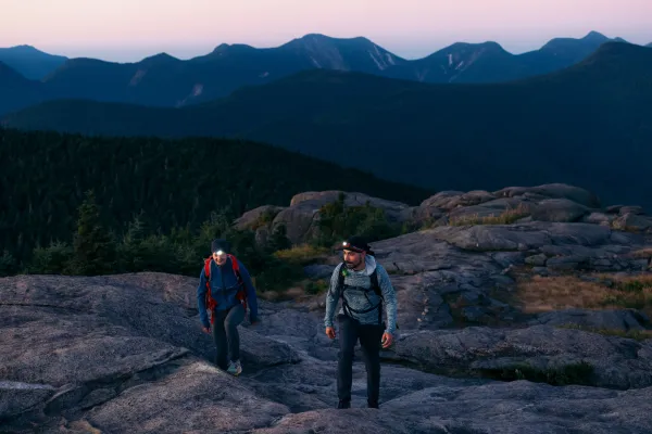 Two people hiking up a rocky ridge