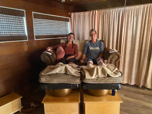 Better Together - two friends happily sit on the warming pedicure chairs