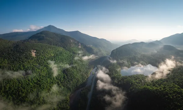 An aerial view of a mountainous area with a road running through it.