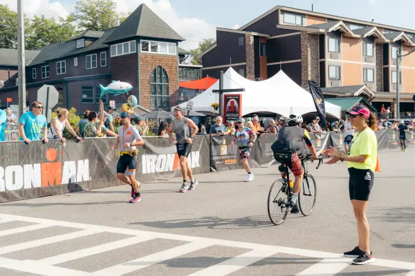 Ironman bikers and runners passing on the road