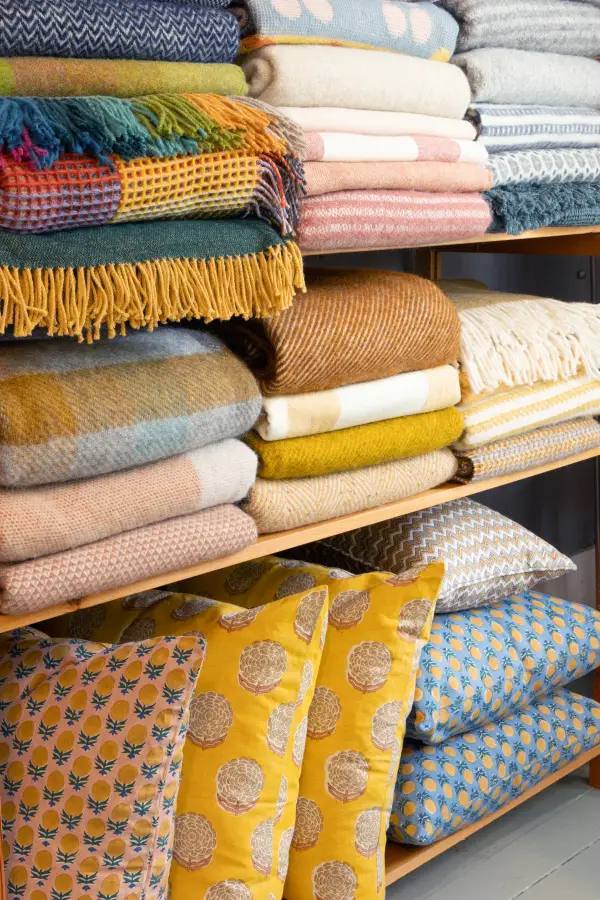 Fine wool blankets and complimentary pillows sit on a shelf
