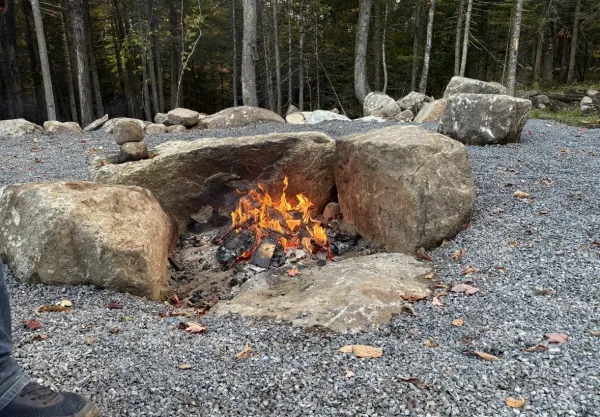 Three boulders arranged in a semi circle to contain a fire pit.