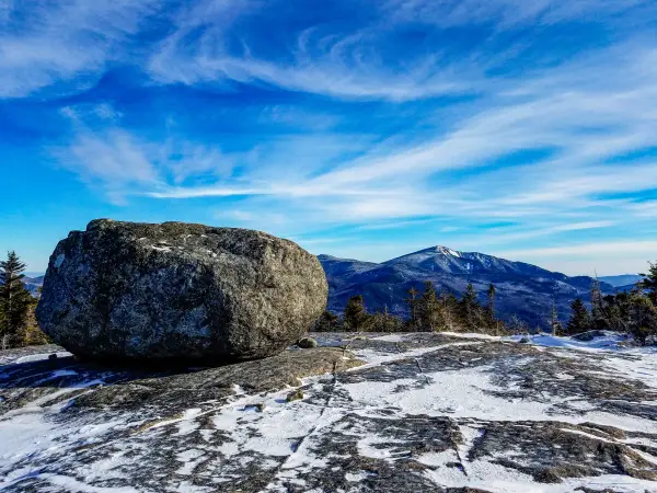 A large boulder on a wintry mountain summit