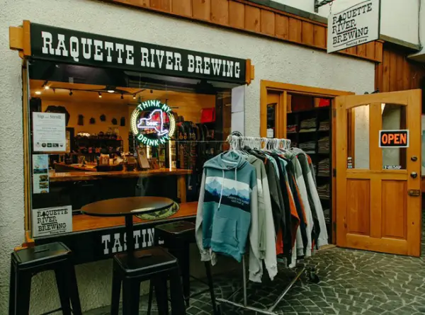 The exterior of the tap room with a rack of branded hoodies