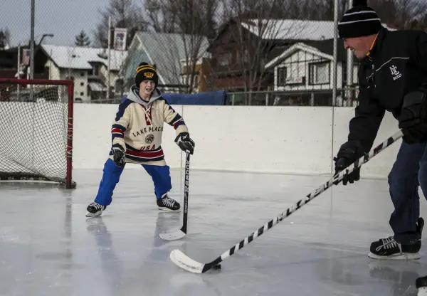 A father and son play hockey