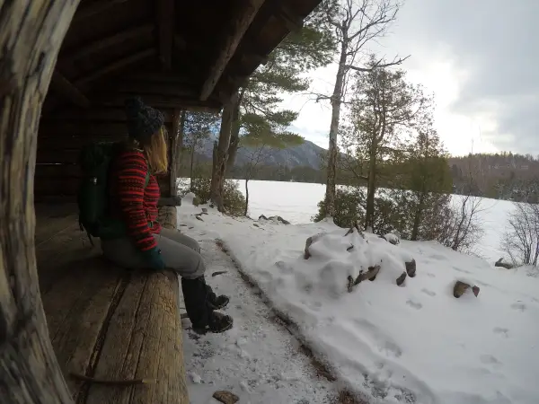 A person sitting at a lean-to in the winter