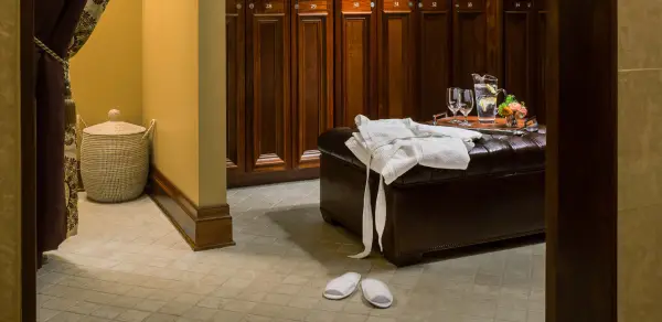 The ladies locker room with refreshments, a lush towel and robe, soft slippers and dark wooden lockers