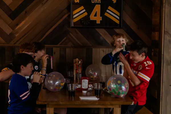 A bunch of boys at a birthday party with balloons filled with colorful confetti and noise makers.  Photo Credit to A. Kelly.