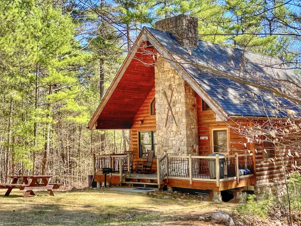 Cabin with stone fireplace, deck, and picnic table