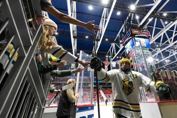 The image shows an indoor ice hockey arena filled with spectators. 