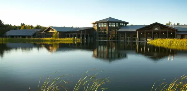View of The Wild Center sitting across a shimmering body of water