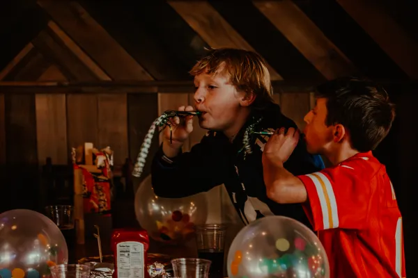 Balloons filled with colorful confetti and kids with noise maker party favors.  Photo Credit to A. Kelly.