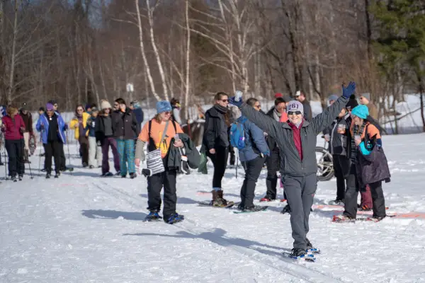 Snowshoers and cross-country skiers on a trail. 