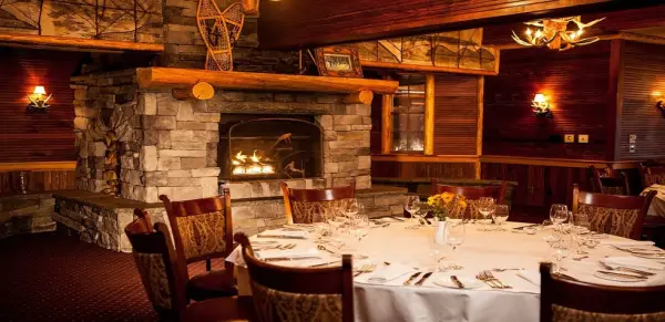 Beautifully appointed dining table in the Wikoff room with grand stone fireplace and large wood beams