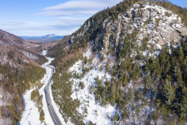 An aerial view of a road winding through a rocky-sided mountain pass.