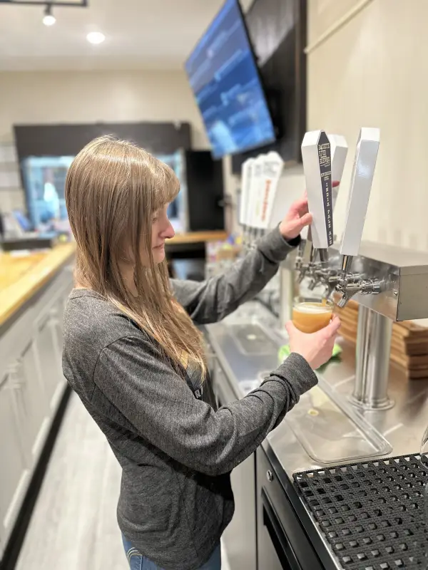 A woman pours a beer